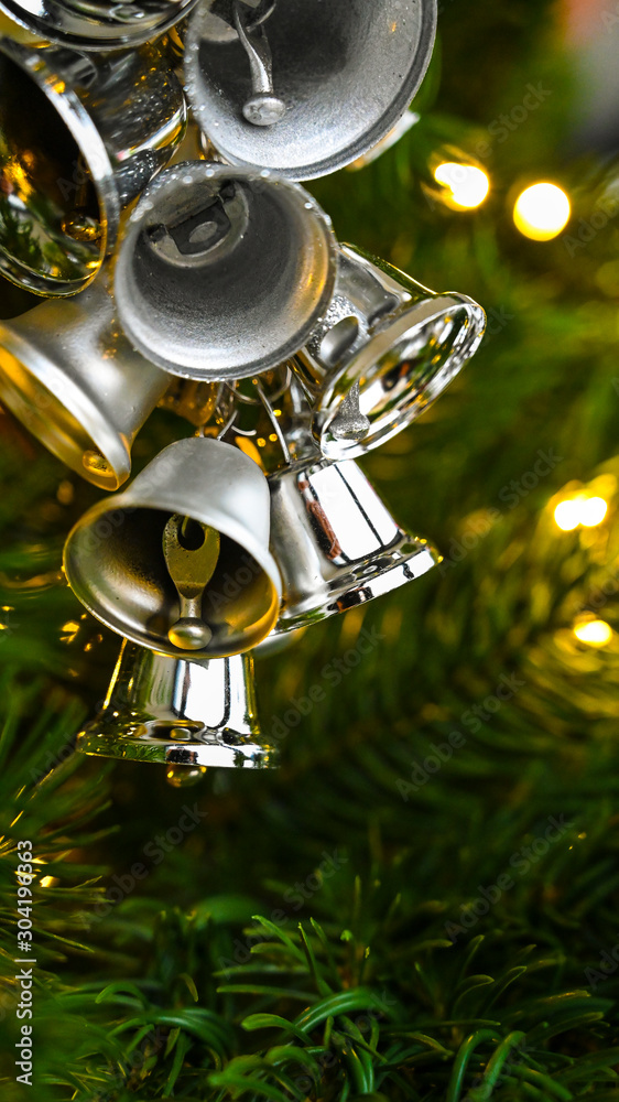 Silver christmas bells on green christmas tree