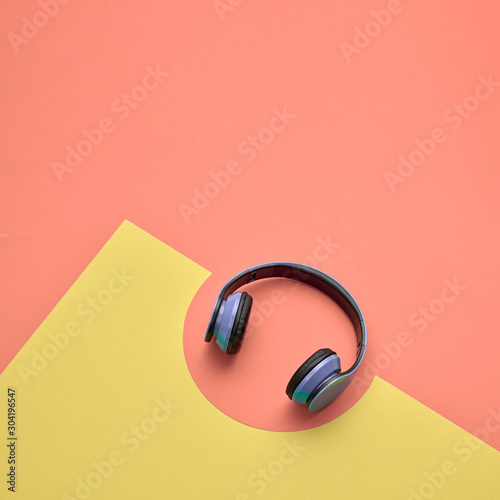 Minimal fashion, Trendy headphones. Music vibration on geometry background. Hipster DJ accessory Flat lay. Art creative summer vibes, fashionable pop art style. Sweet pastel design coral color