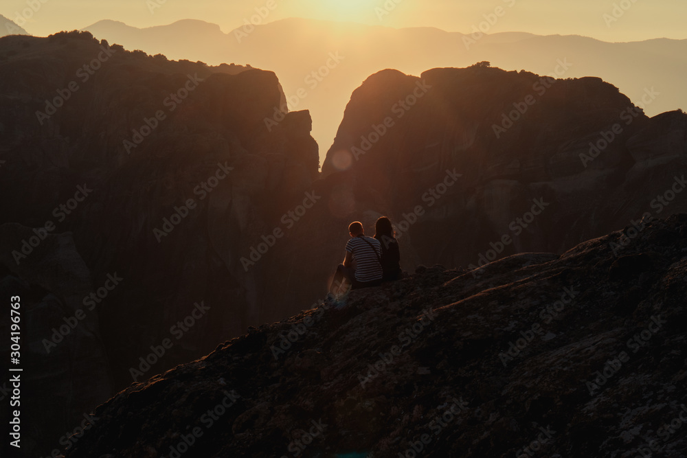 Couple Enjoying The Romantic Sunset Over The Rocks Of Meteora