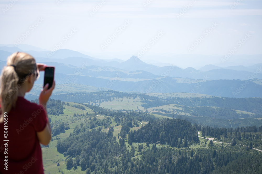 girl on a smartphone photographs of mountains and forest in zlatibor  area serbia