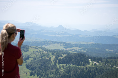 girl on a smartphone photographs of mountains and forest in zlatibor area serbia
