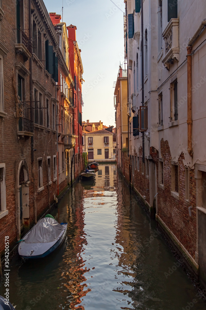 Venice, Italy. Boats in a narrow canal between old houses