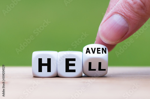 Hell or heaven? Hand turns a dice and changes the word "hell" to "heaven".