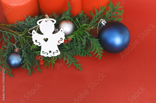 spruce branches with Christmas balls of different colors and  4 red Christmas candles on a red background in the corner place for text. concept new year and Christmas