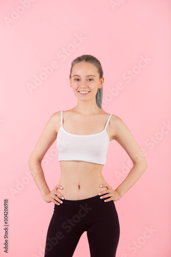 beautiful young slim woman in sportswear on pink background © Alexandr