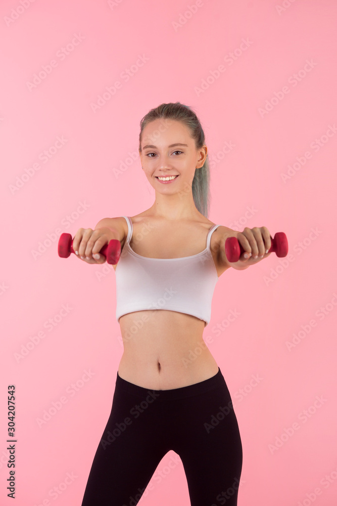 beautiful young woman with dumbbells in hands on pink background beautiful young woman with dumbbells in hands on pink background