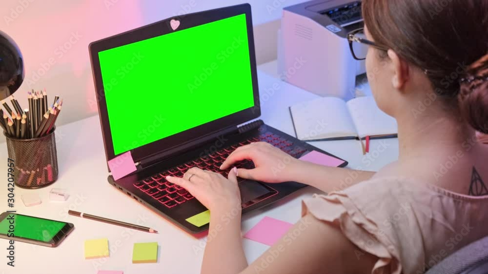 Pretty woman sitting at the desk in the office, typing on the notebook. ProRes 10 bit. 4K UHD. Isolated Green screen. Pretty woman sitting at the desk in the office, typing on the notebook. ProRes 10 bit. 4K UHD. Isolated Green screen.
