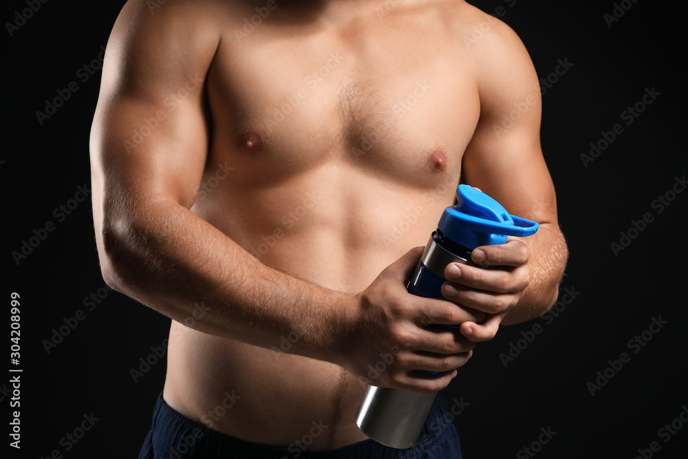 Naklejka premium Handsome male bodybuilder with protein shake on dark background