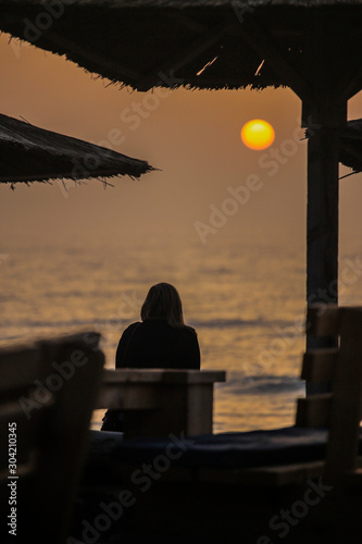 Girl watching sunrise on sea resort