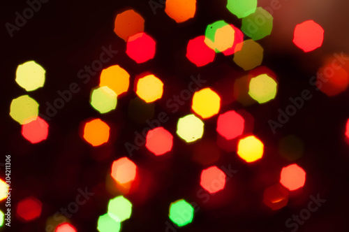 unfocused glowing shiny multicolored lights with geometric shape with blurred dark background for wallpaper and design