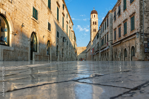 Dubrovnik city  morning sun illuminates an old street  ancient polished tiles glisten