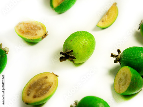 Fruit abstract background. Feijoa on a white background. Whole feijoa and sliced fruit quite near