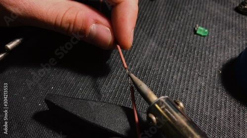 Young engineer soldering a wire. Close up