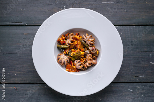 Fototapeta Naklejka Na Ścianę i Meble -  Top view Vegetarian paella with octopus on a white plate. Mediterranean food. Ketogenic Diet Recipes