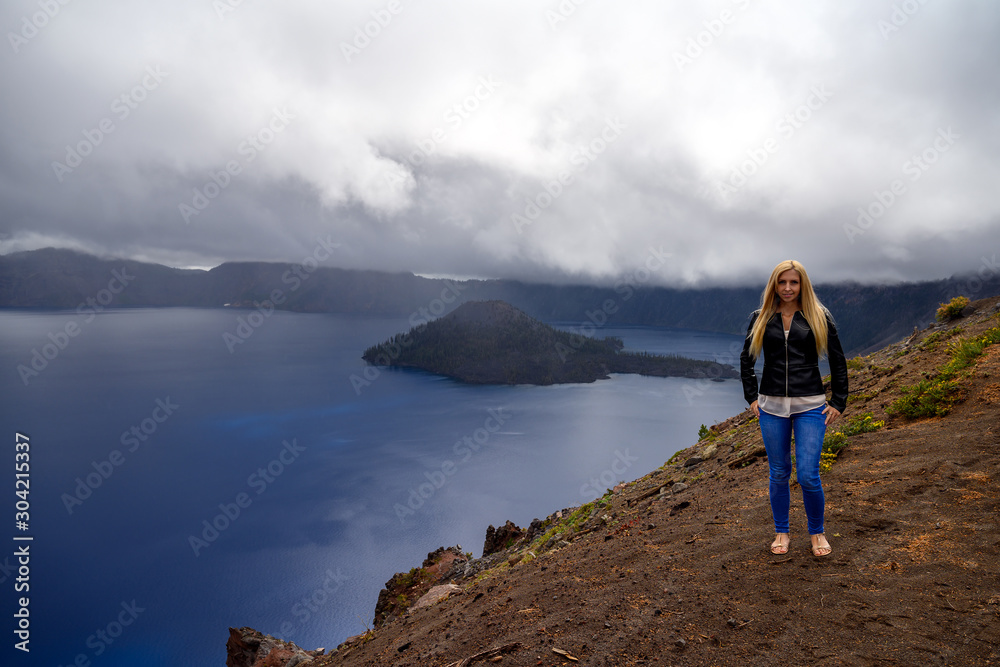 Attractive blond nature lover posing for a photo at the Crater Lake National Park, Oregon USA