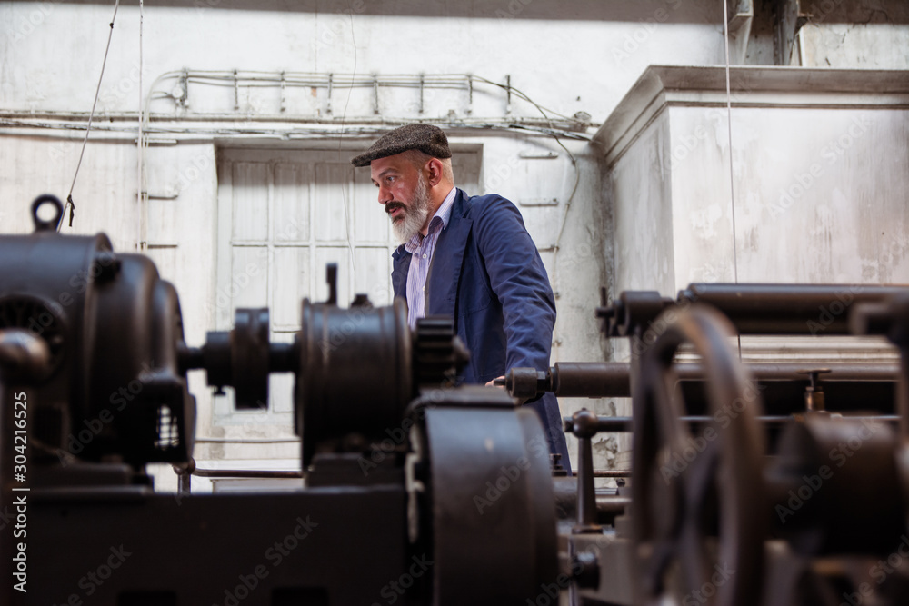 Tired worker working on a printing press Tired worker working on a printing press