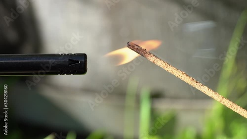 Close up of an Incense stick being lit and burning outside