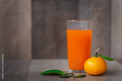 The fresh juice of citrus fruits on the wooden background. Close up