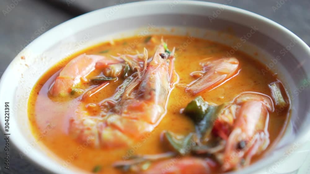 Spicy Soup with Prawn in a bowl. Tom Yum Goong. Slide shot. Thai food