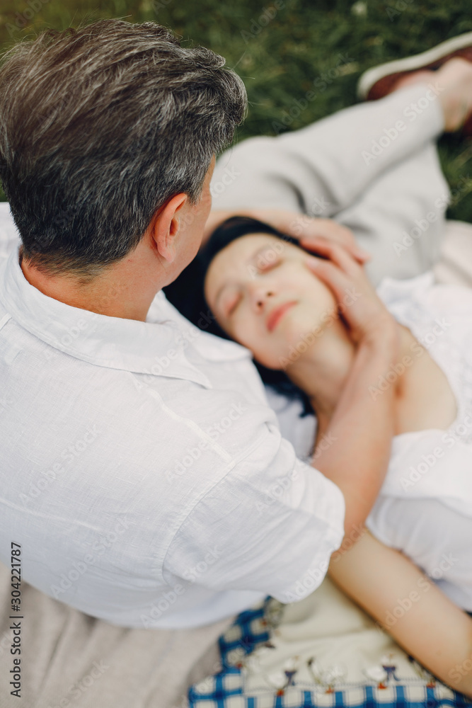 Adult couple in a summer field. Handsome senior in a white shirt. Woman in a white blouse Adult couple in a summer field. Handsome senior in a white shirt. Woman in a white blouse
