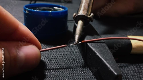Young engineer soldering a wire. Close up