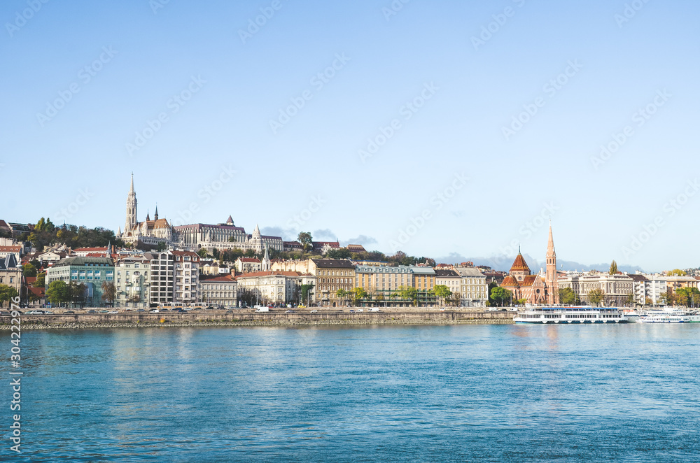 Danube river in Budapest, Hungary. The historic old town in the background with famous Matthias Church or Fishermans Bastion. Cityscape of the Hungarian capital. Tourist destinations Danube river in Budapest, Hungary. The historic old town in the background with famous Matthias Church or Fishermans Bastion. Cityscape of the Hungarian capital. Tourist destinations