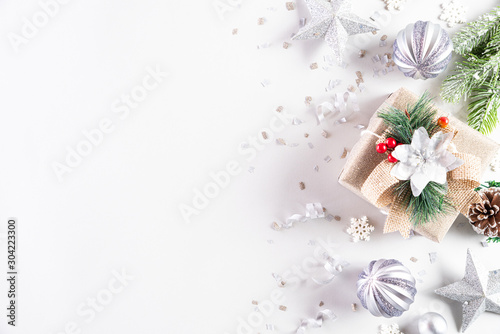 Christmas holidays composition Top view of gift box with Christmas tree decoration and red berries on white background with copy space for text.