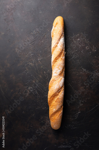 Fresh hot baguette on dark background.