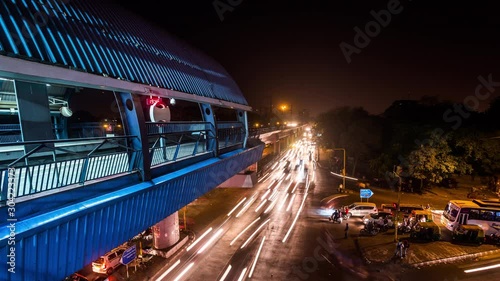Elevated metro station above road intersection in New Delhi downtown time lapse at night