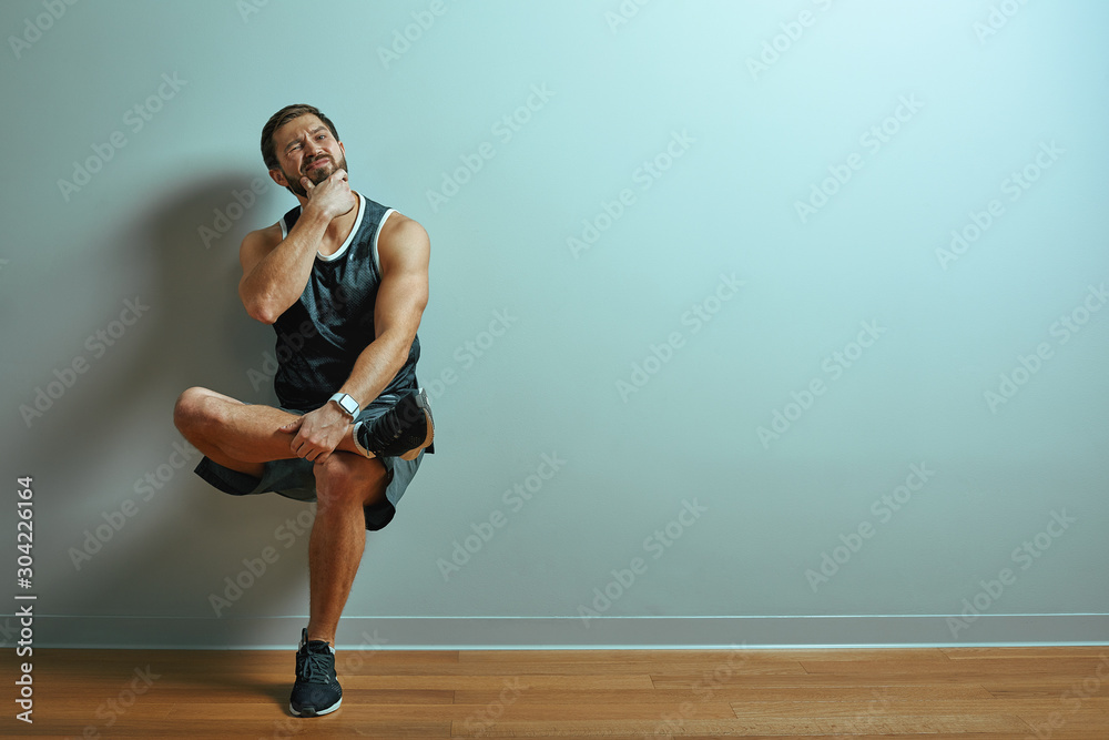 Portrait of caucasian handsome man smile wearing t-shirt posing against studio wall pointing with index fingers at copy space for advertisment