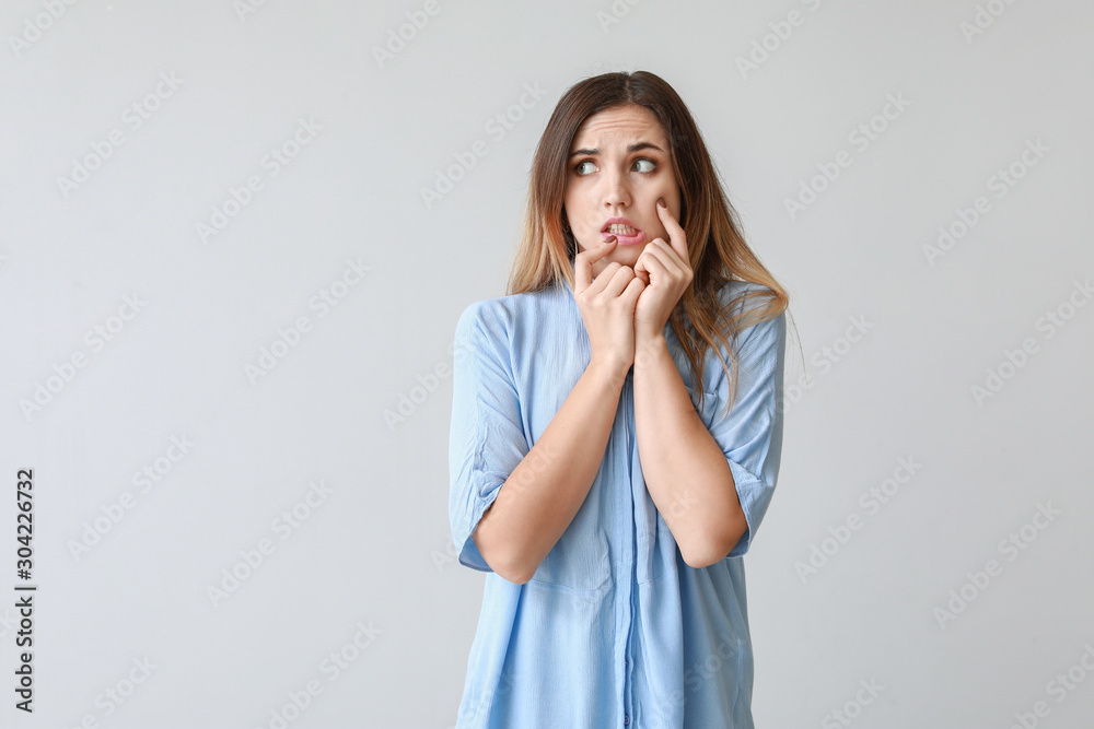 Portrait of worried young woman on light background Portrait of worried young woman on light background