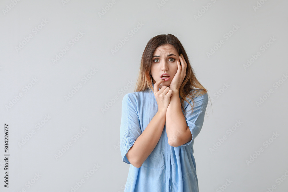 Portrait of worried young woman on light background Portrait of worried young woman on light background