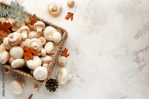 Basket with fresh mushrooms on white background