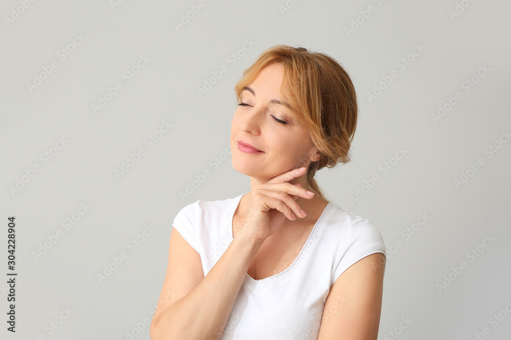 Mature woman with healthy skin on light background Mature woman with healthy skin on light background