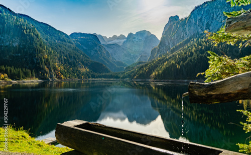 Bergsee mit alpinen Holzbrunnen photo