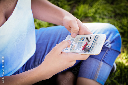 Women's hands holding smartphone showing statistics about company growth