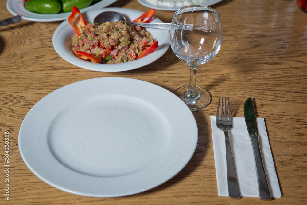 Table setting on wooden table . Dinner place setting. A white plate with silver fork and Wine glasses isolated on wood table. top view . Set of a dish with spoon, fork and knife on wooden table. Table setting on wooden table . Dinner place setting. A white plate with silver fork and Wine glasses isolated on wood table. top view . Set of a dish with spoon, fork and knife on wooden table.