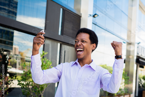 Businessman excited  looking at cell phone. © Mego-studio