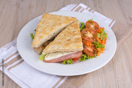 Craft sandwich with oregano, ham, cheese and salad