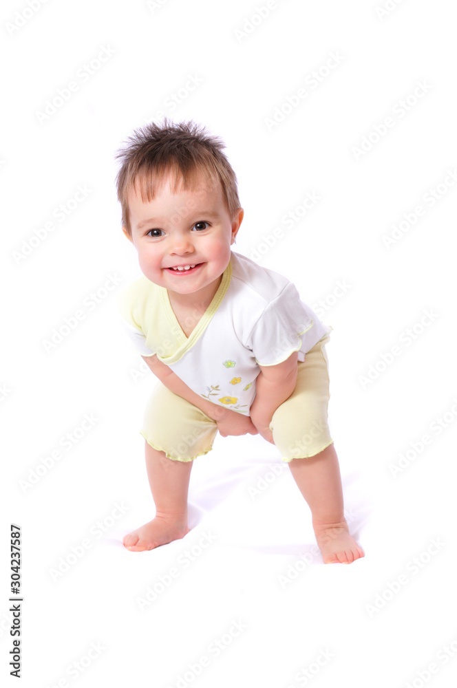 Happy baby girl in child wear bending down Happy baby girl in child wear bending down