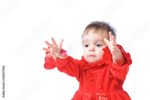 Funny little girl plays with soap bubbles
