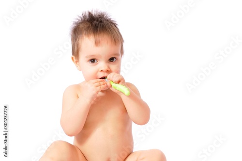 Baby girl holding her first green toothbrush