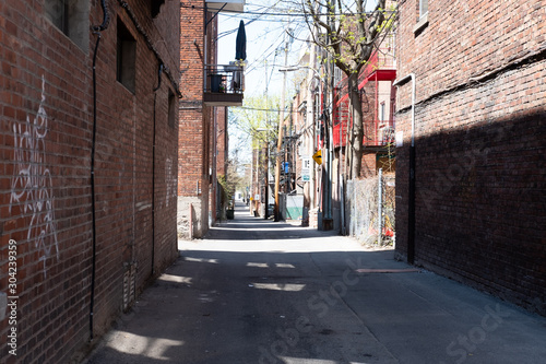 A lane lined with brick houses, telephone poles and fencing