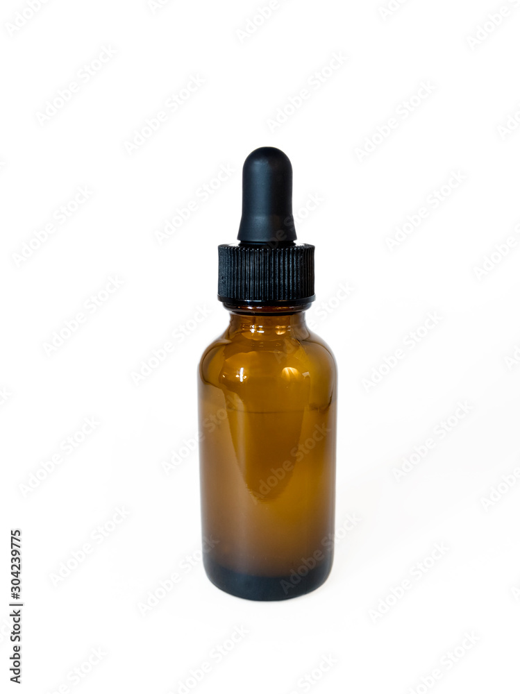 Cannabis extract oil, known as CBD, in an orange tincture bottle on a plain white background