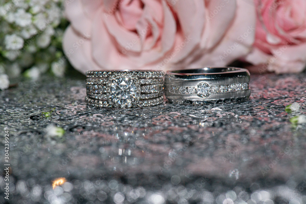 Blingy white gold wedding rings with diamonds on glass reflective surface Blingy white gold wedding rings with diamonds on glass reflective surface