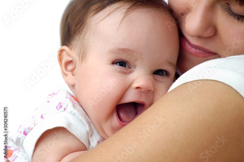 Cute little baby smiling on mothers shoulder