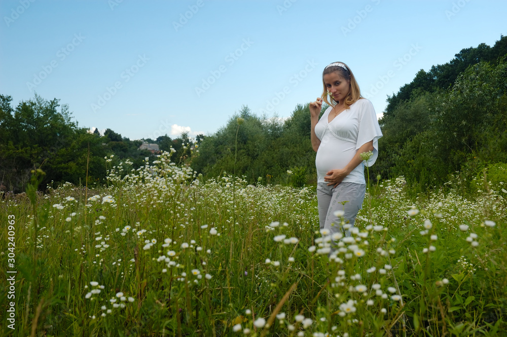 Beautiful pregnant woman relaxing outside in the park Beautiful pregnant woman relaxing outside in the park
