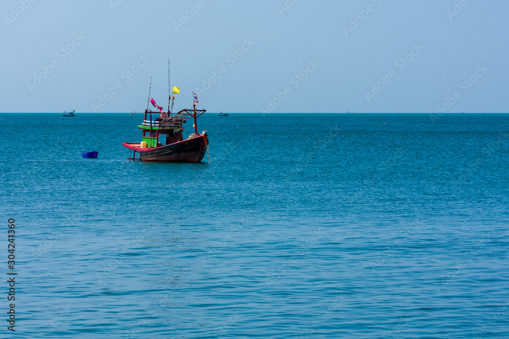 A small fishing boat anchored near Bang Saen Beach in the Gulf of Thailand.