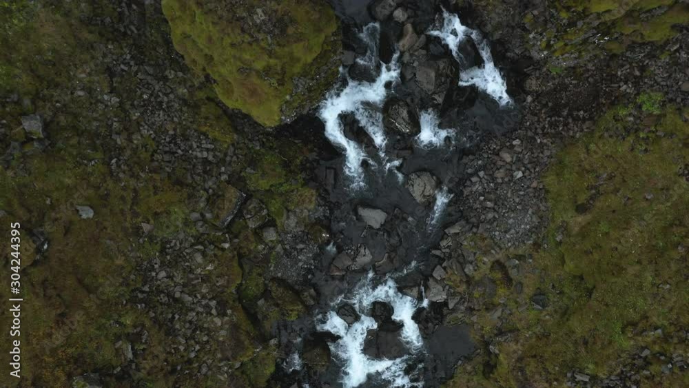Overhead view of a small stream from a waterfall, with the water rushing over rocks Overhead view of a small stream from a waterfall, with the water rushing over rocks