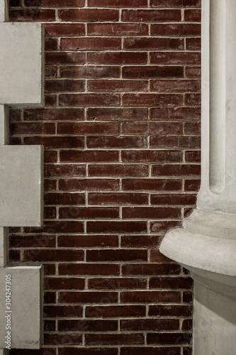 Fragment of a white column on a background of a red brick wal photo